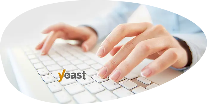 Mains tapant sur un clavier illustrant la rédaction web et les mots de liaison SEO.