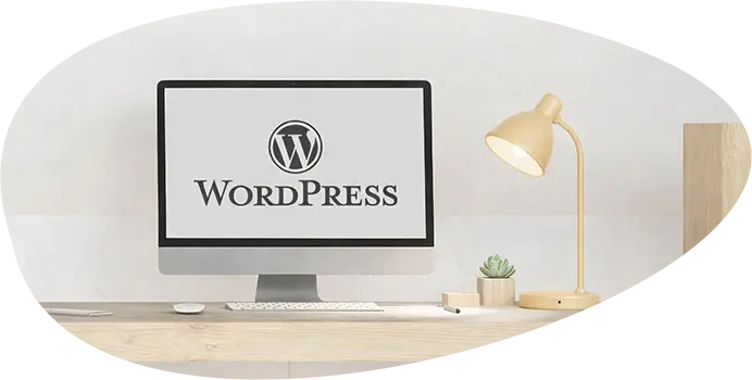 Pourquoi choisir WordPress : écran affichant le logo WordPress sur un bureau en bois.