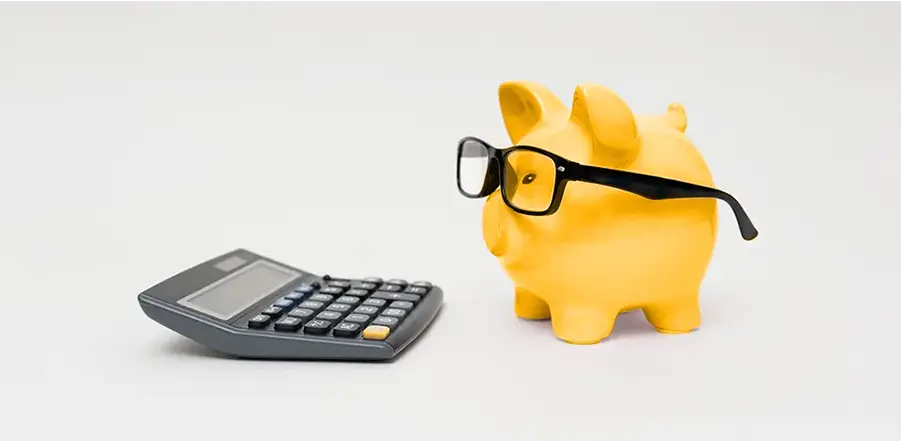 Tirelire face à une calculatrice, symbole de la création de site web à Strasbourg à prix abordable.