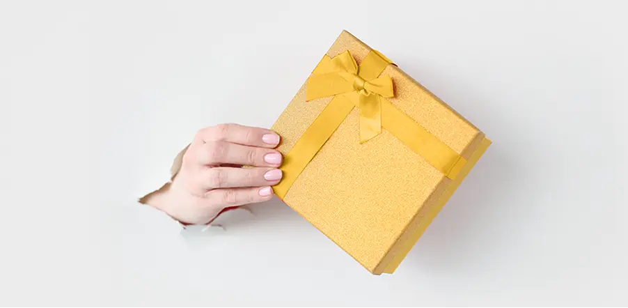 Main tendant un coffret cadeau, symbole des prestations gratuites de notre agence web Bas-Rhin.