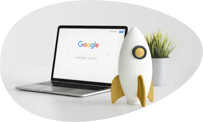 Ordinateur affichant Google, accompagné d’une fusée représentant l’accompagnement SEO