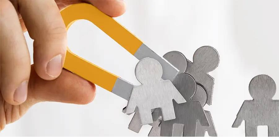 Aimant attirant des silhouettes, symbole d’un accompagnement SEO qui attire des visiteurs.