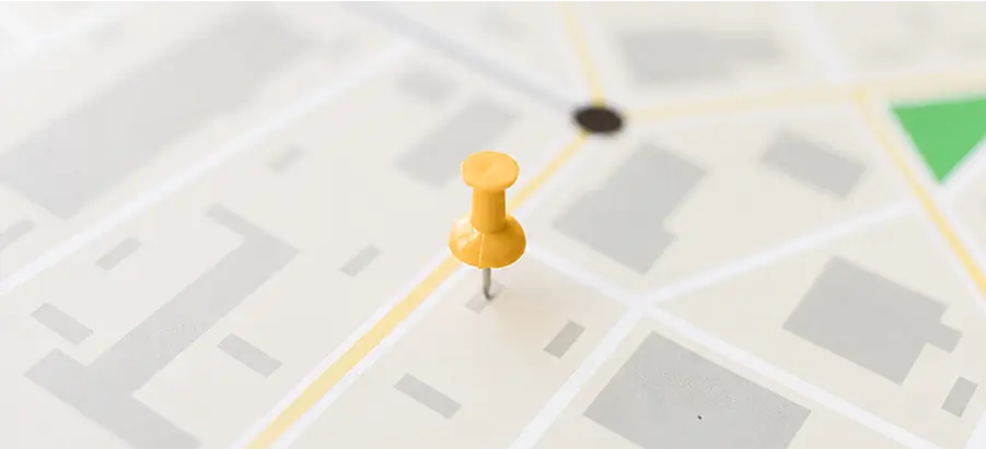 Épingle jaune plantée sur une carte de ville, illustrant le SEO local