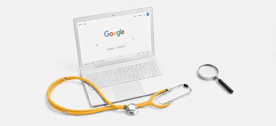 Stéthoscope et loupe posés devant un ordinateur affichant Google, symbolisant le diagnostic SEO