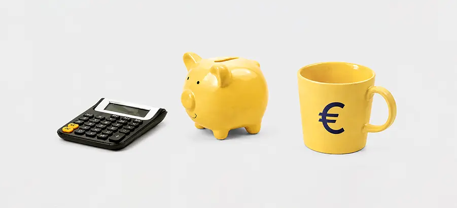 Calculatrice, tirelire et mug marqué d'un symbole euro, évoquant le tarif d'un audit SEO