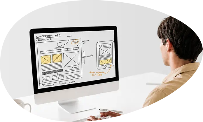 Développeur web devant un écran affichant le croquis pour la refonte d'un site internet